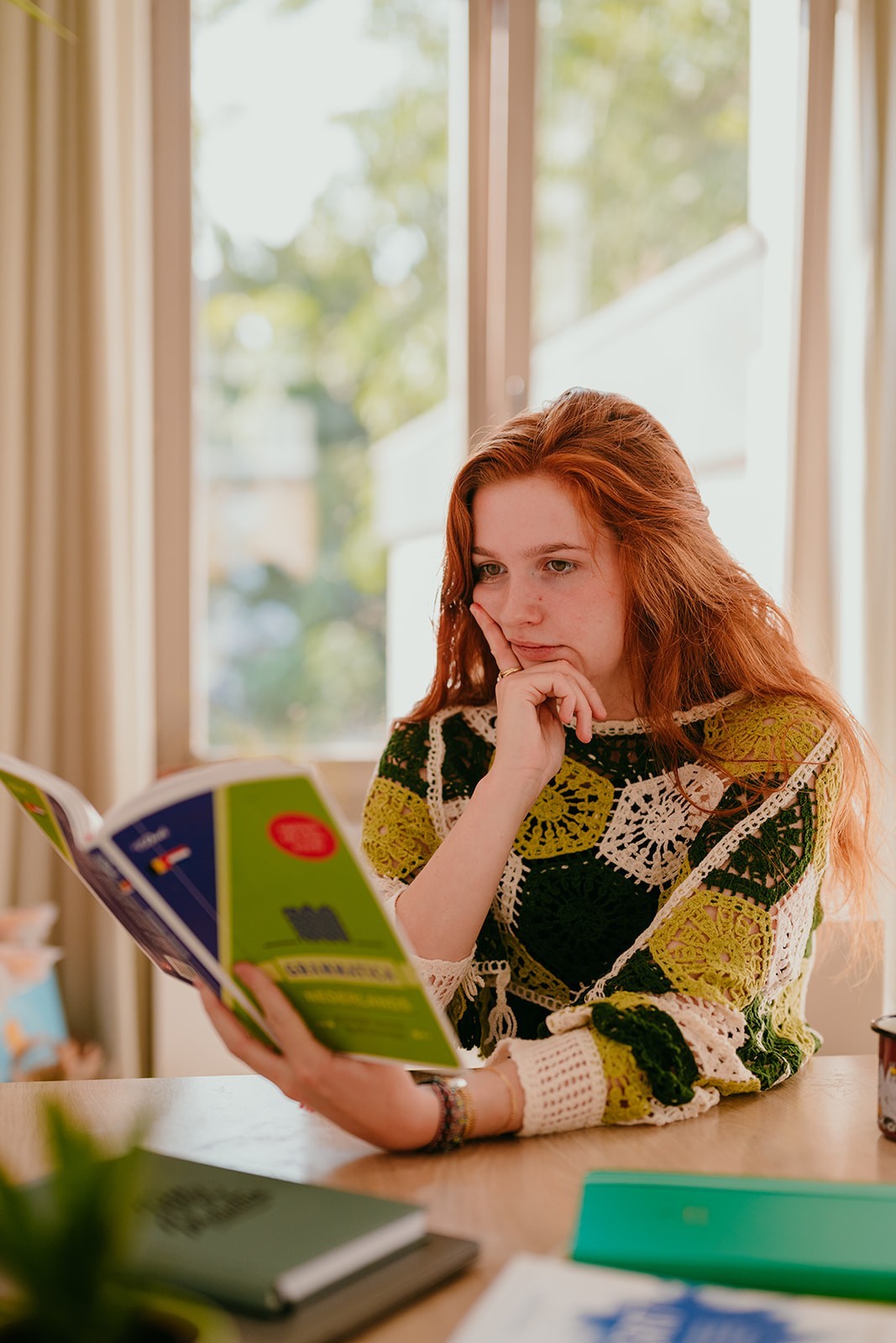 Yasmine looking sad and confused at a grammar book