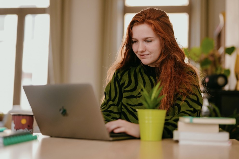 Yasmine from Learn Dutch with Yas sitting behind a desk while working on a laptop