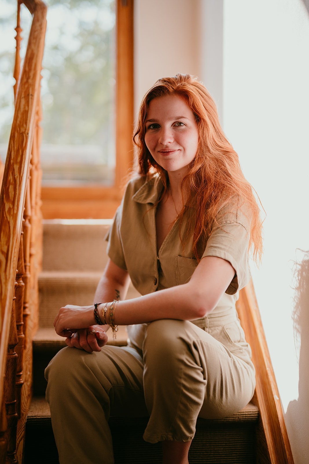 Yasmine, the founder of Learn Dutch with Yas, sitting on stairs while smiling at the camera