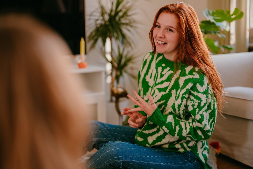 Yasmine, the founder of Learn Dutch with Yas, holding a conversation with another person while counting her fingers